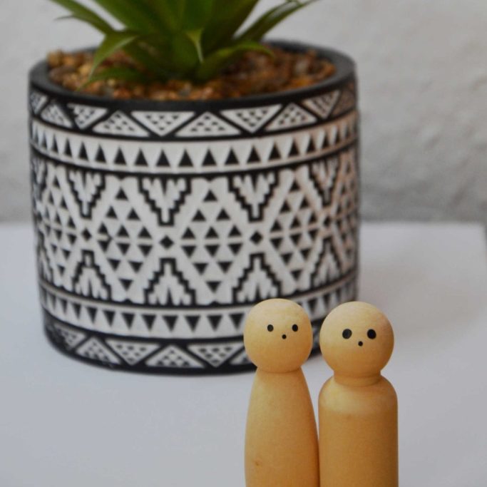 Zwei Holzfiguren als Symbol für therapeutische Beziehung vor grüner Pflanze – Psychotherapie & EMDR-Traumatherapie in Saarburg, Trier.